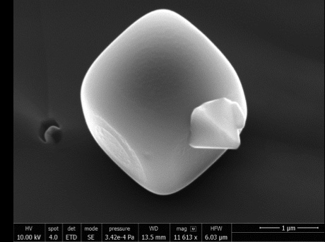 Secondary electron image of halite cube approximately ~1 μm across with an adhering chalcopyrite crystal that was trapped within a fluid inclusion hosted in quartz from Bingham Canyon, Utah. 