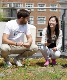 Xi Liu on a green roof with two fellow students