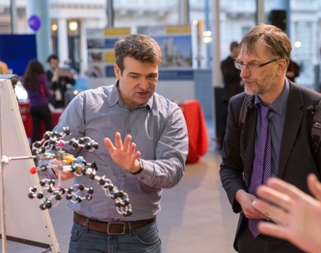Researcher gesturing towards molecular model