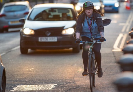 A female cyclist rides along a city street