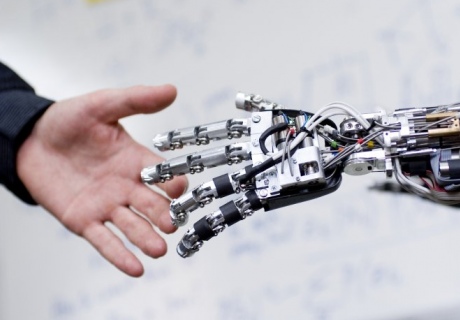 A human and robot hand reach out to each other