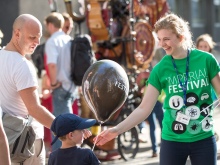 A Festival volunteer hands out balloons