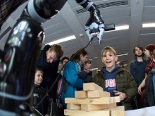 A boy operates a robotic arm