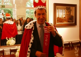 James Durrant wearing red and ermine crown and cape, holding the royal sock
