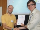 Dr Davide Moia recieving talk prize certificate
