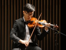 A violin player entertains guests
