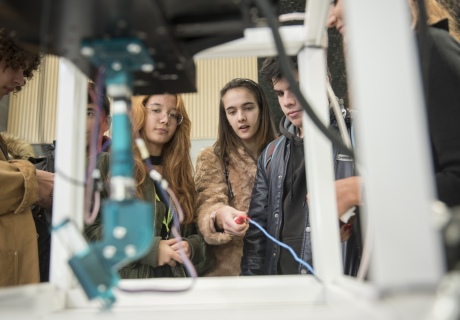 Students interacting with a mechanical experiment