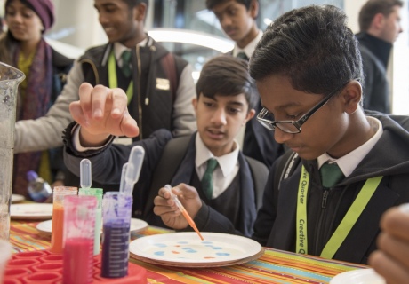School students taking part in an experiment using milk, soap and watercolours