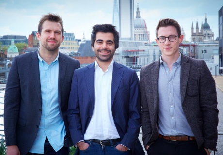 A trio of men stand in front of the London skyline