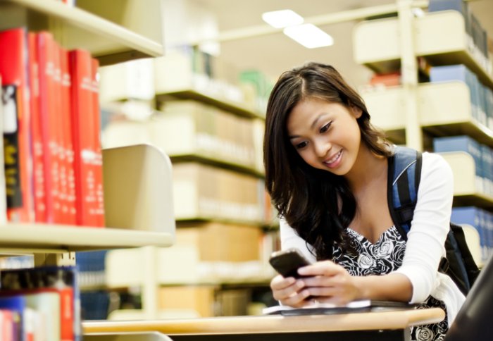 Girl texting in a library