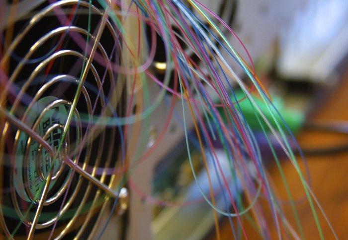 A computer fans surrounded by wires.