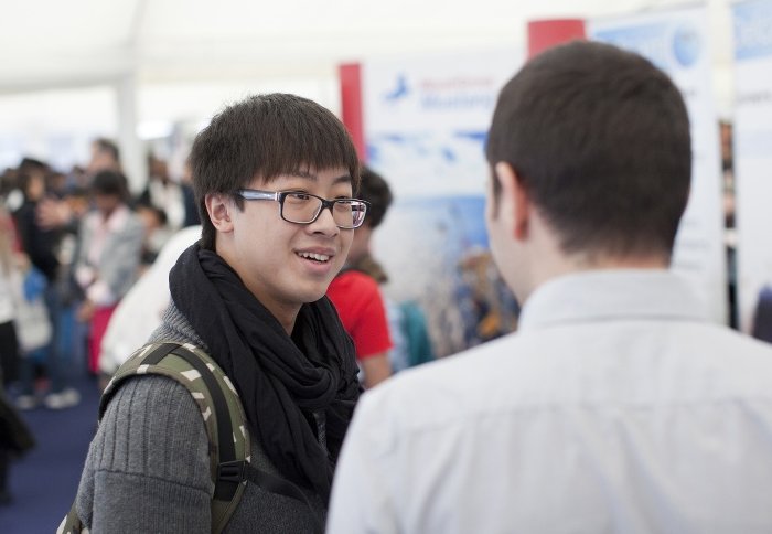 A student talks with an employer at a careers fair.