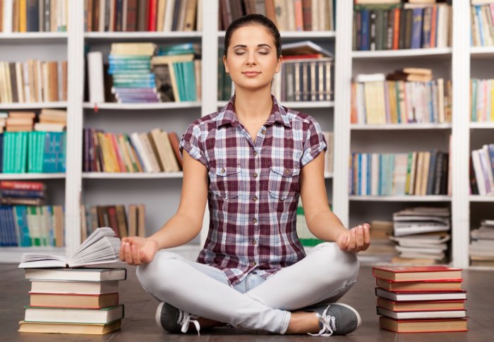 Girl meditating in a Library