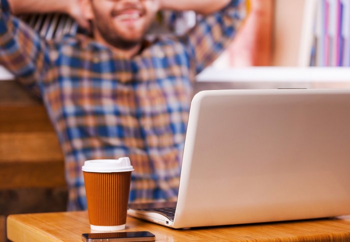 Young man with hot drink in a Library