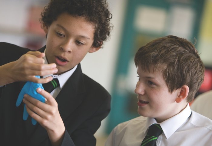 Some pupils conduct a science experiment.