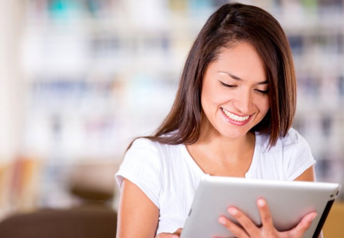 Girl with iPad in a library