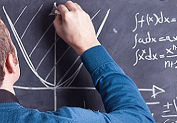 Image of someone working out mathematical equations on a blackboard