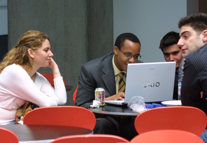 Students study around laptop