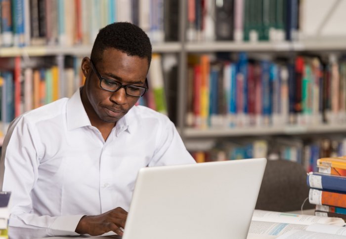 Man using a laptop in a library