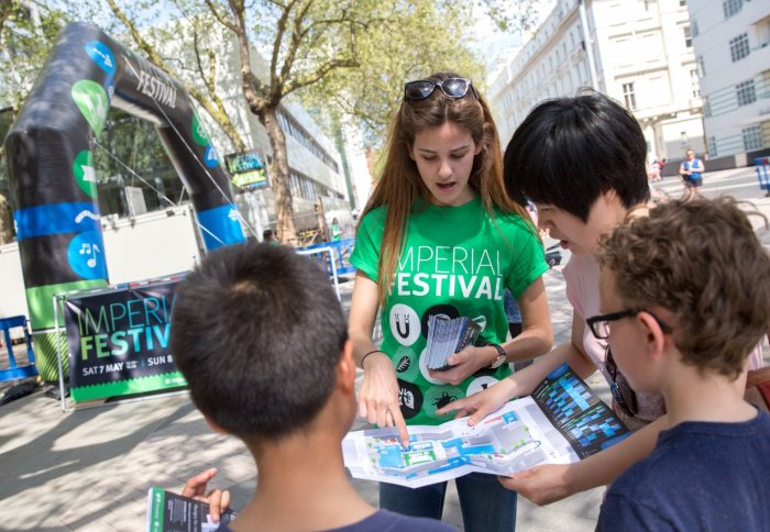 person in green Festival T-shirt shows visitors map
