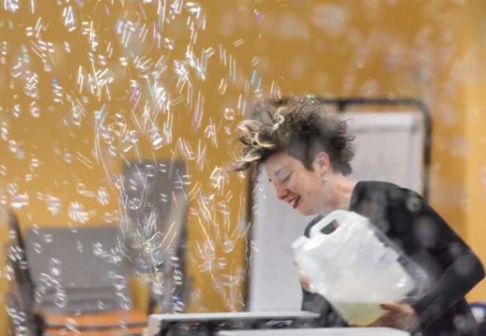 Woman making clouds of bubbles at festival of science