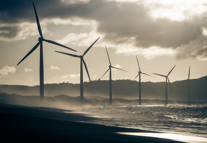 Wind turbines in the sea with dark clouds behind