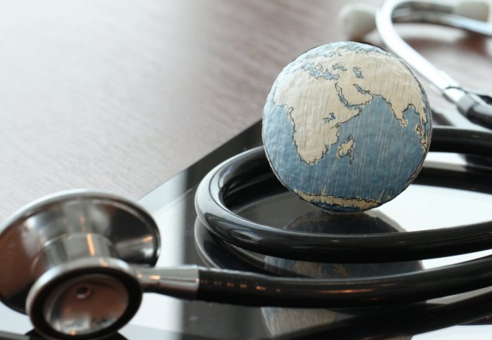 Small model of a globe wrapped in a stethoscope on a table.