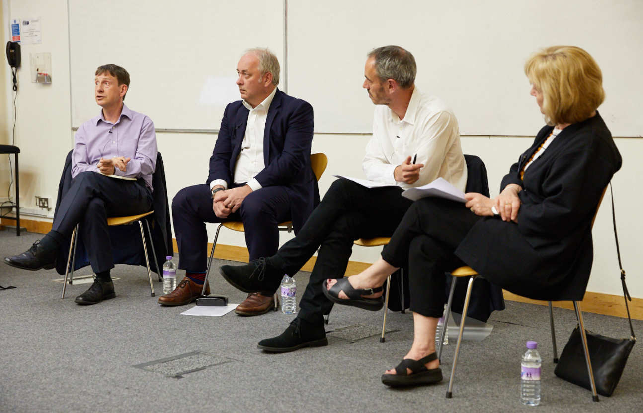 four people sitting on chairs in a row