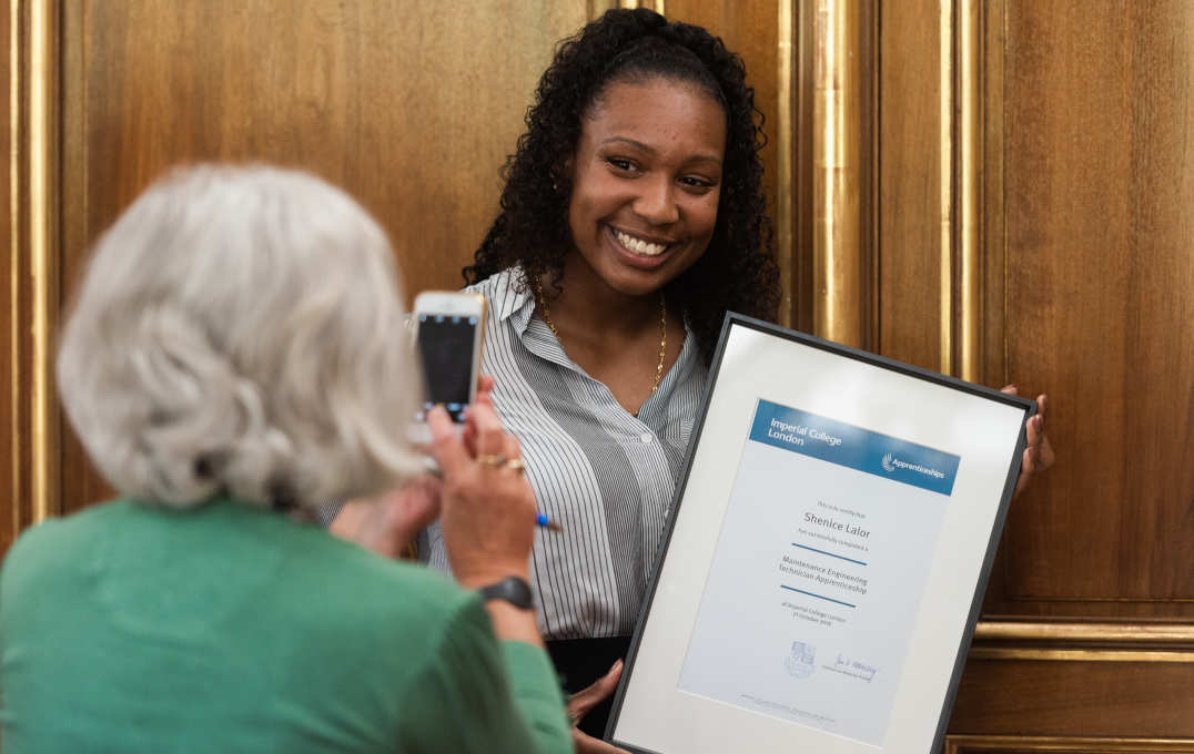 woman with certificate poses for a picture