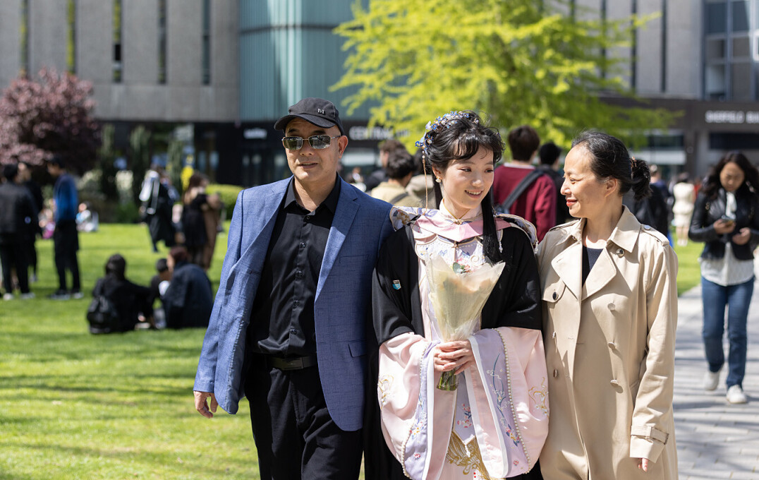 A student walking through campus with their family