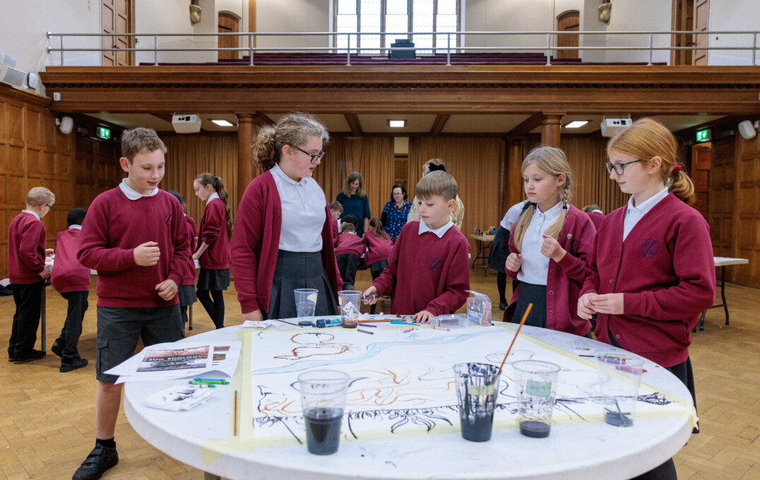 Children stood round a table making artwork