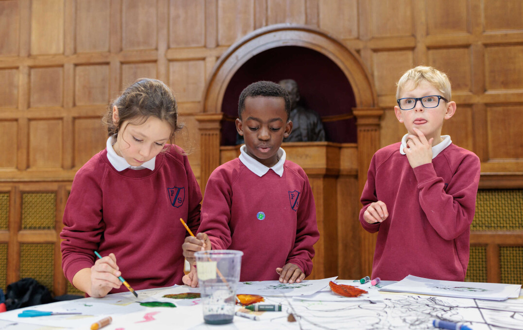 Children stood round a table making artwork