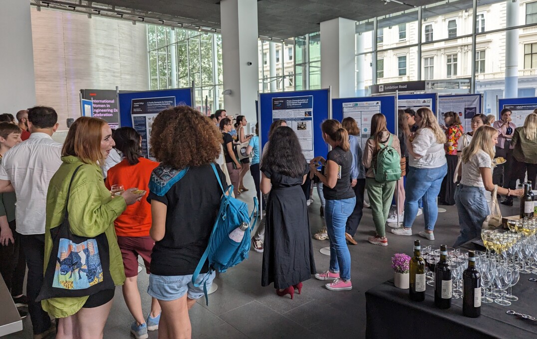 A table of refreshements in the foregroudn with attendees at the poster exhibition