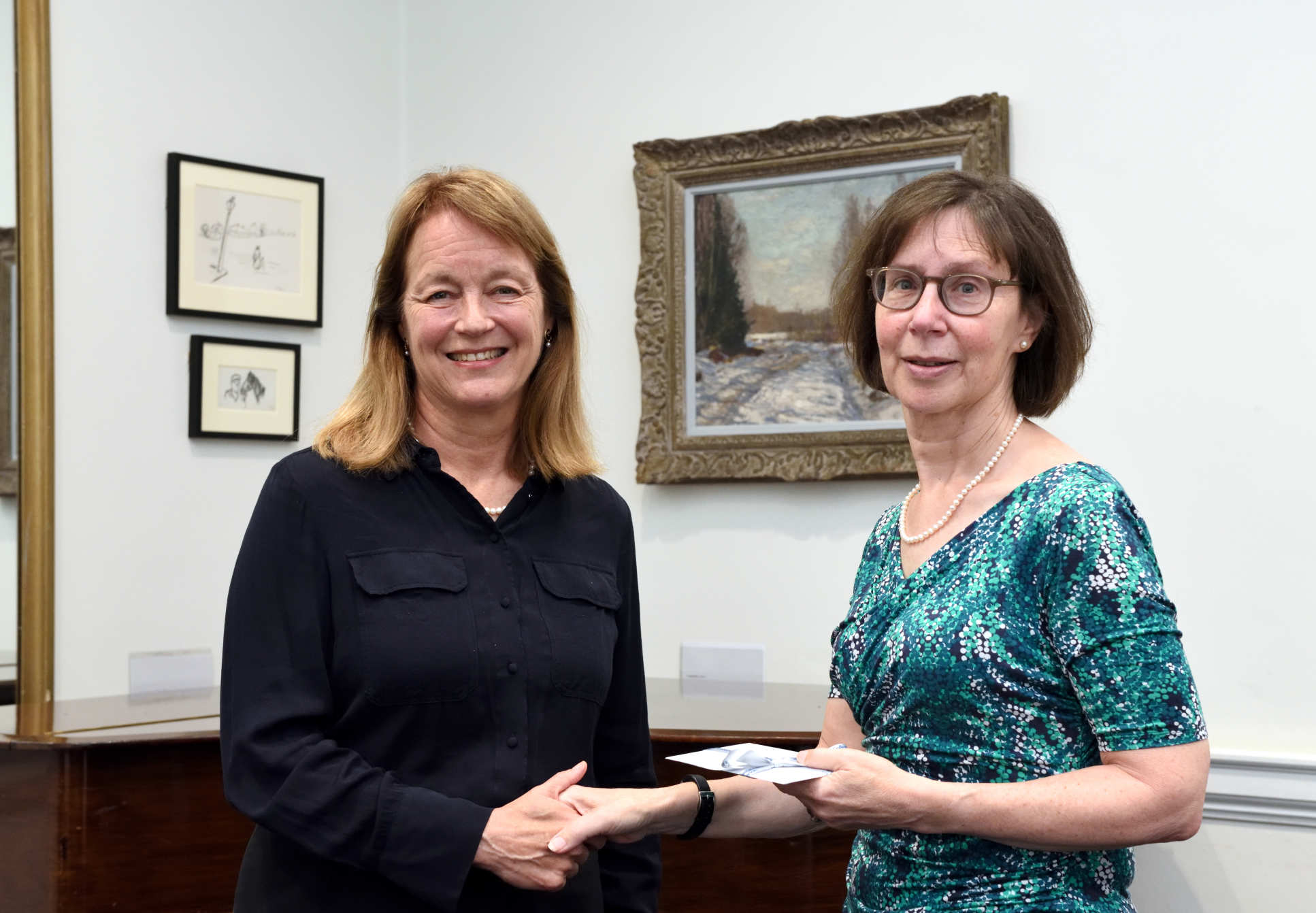 a woman shakes hands with another woman