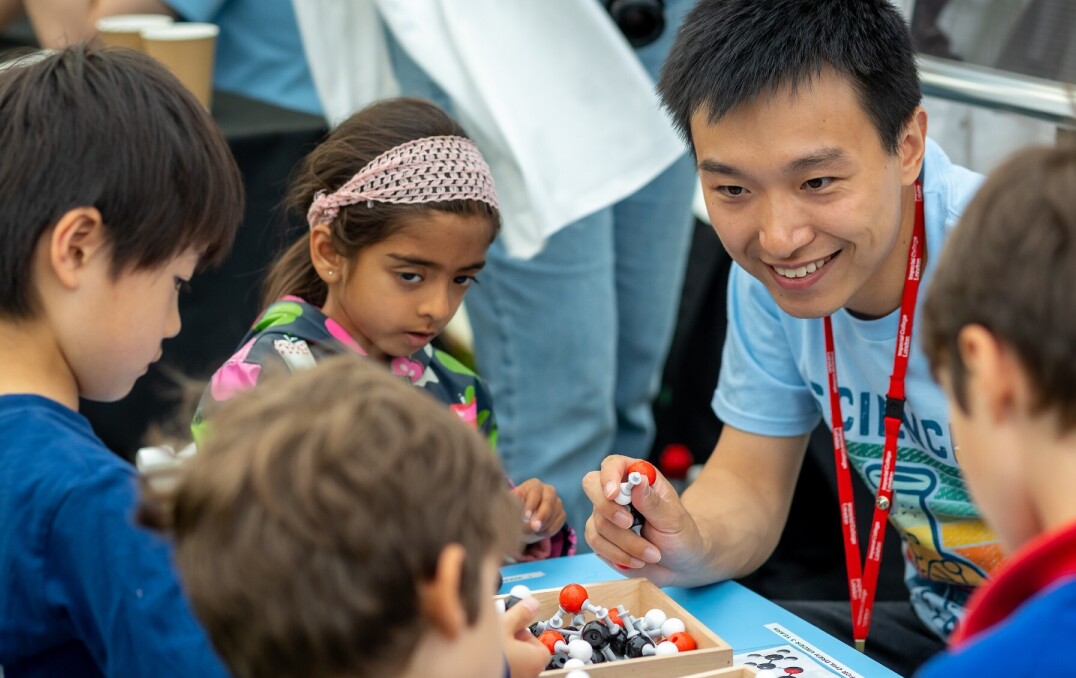 A group of children talking to a Festival volunteer.