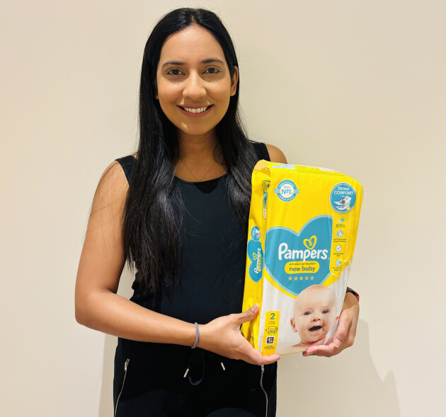 Woman holding a bag of Pampers nappies