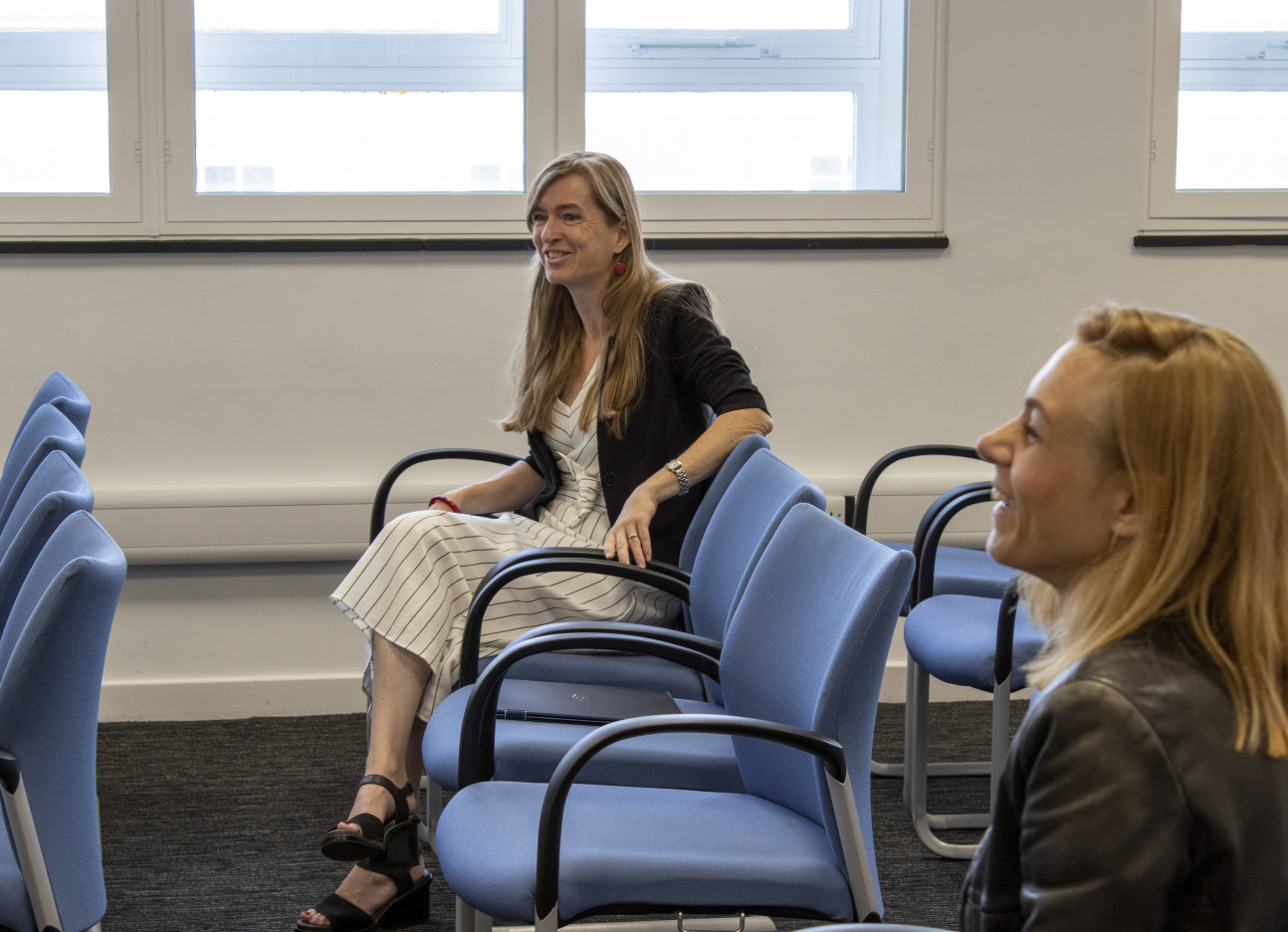 Two women seated and laughing