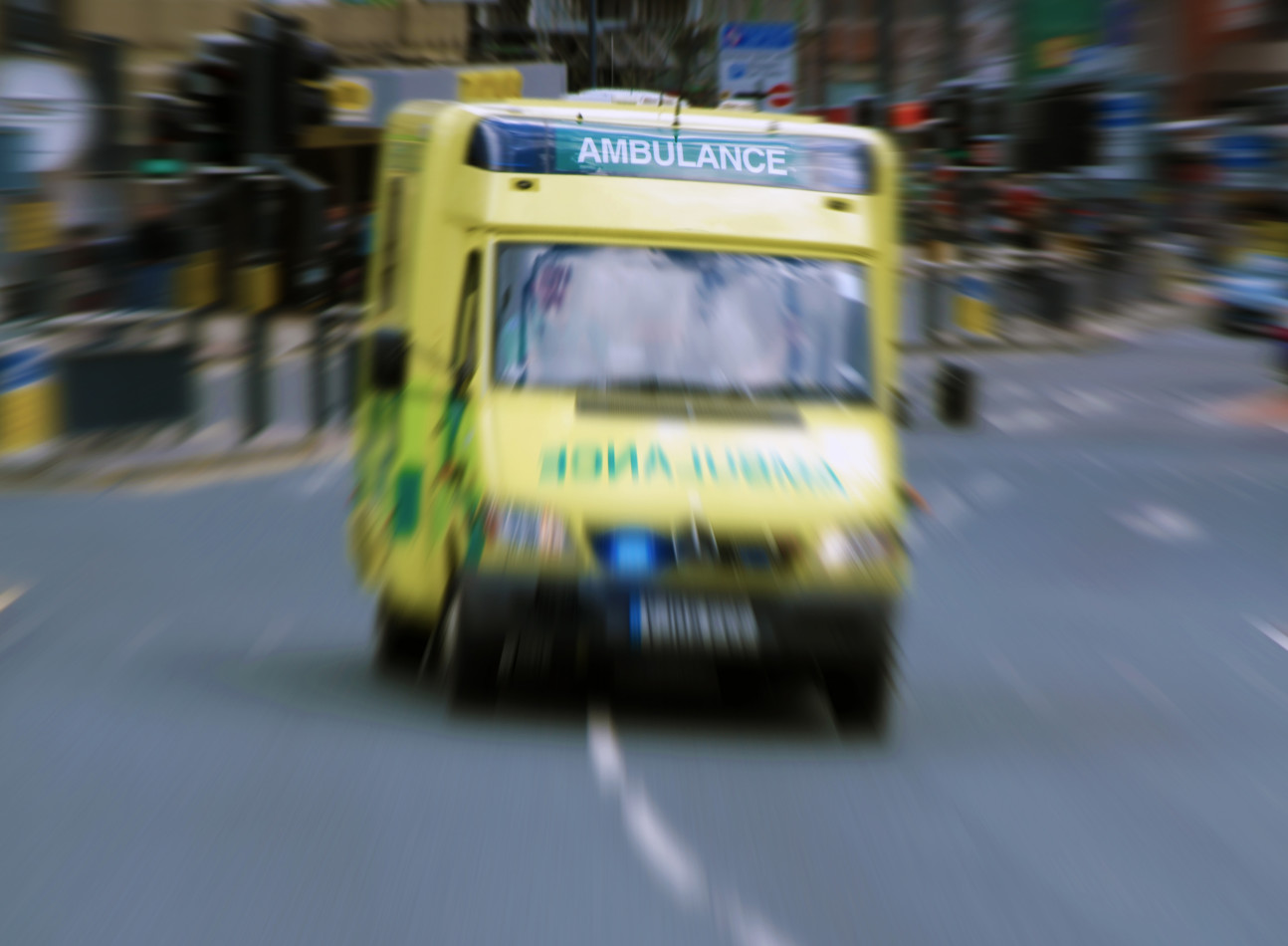 An ambulance speeding through a busy street