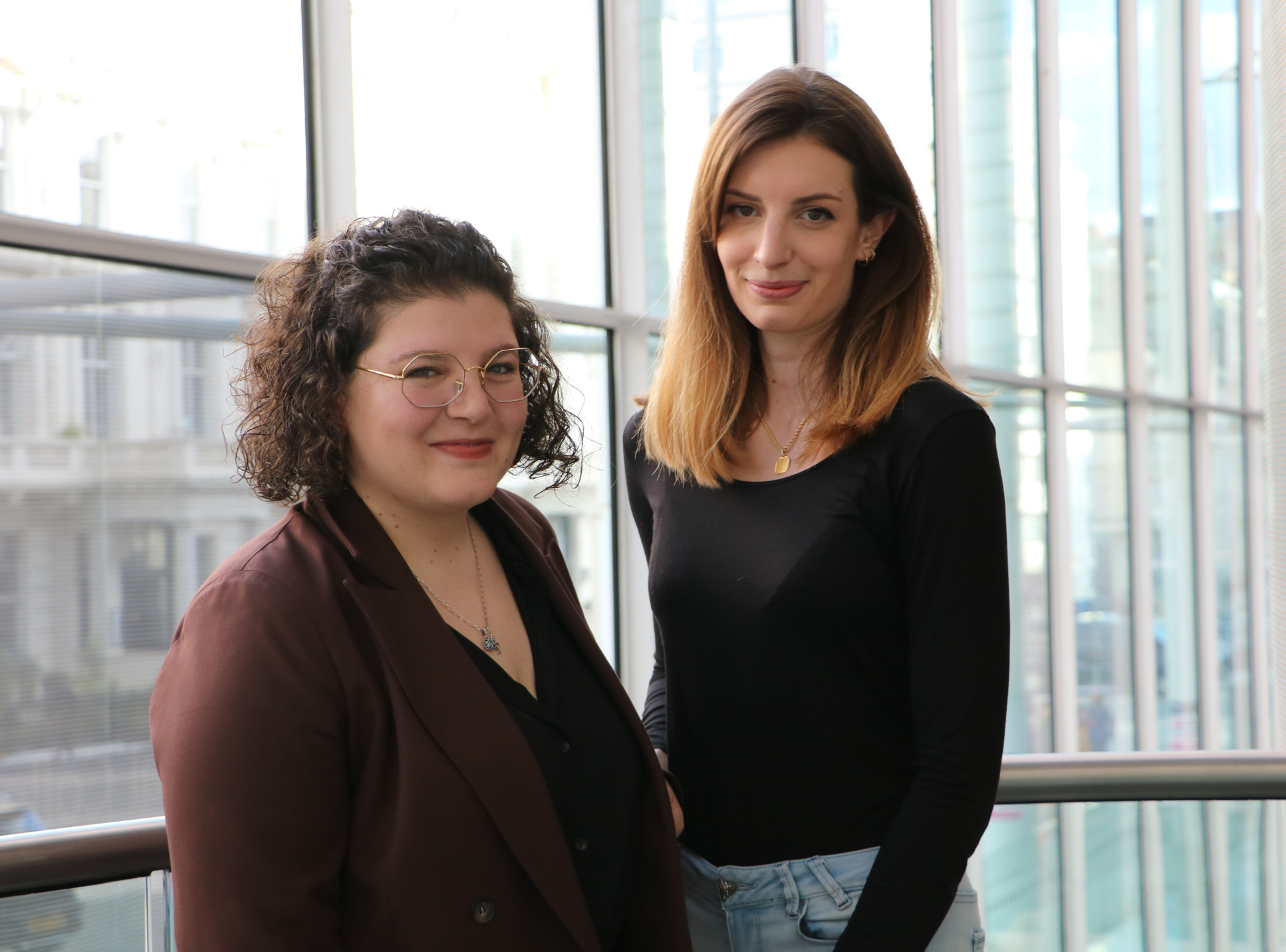 Two people stand in the College main entrance