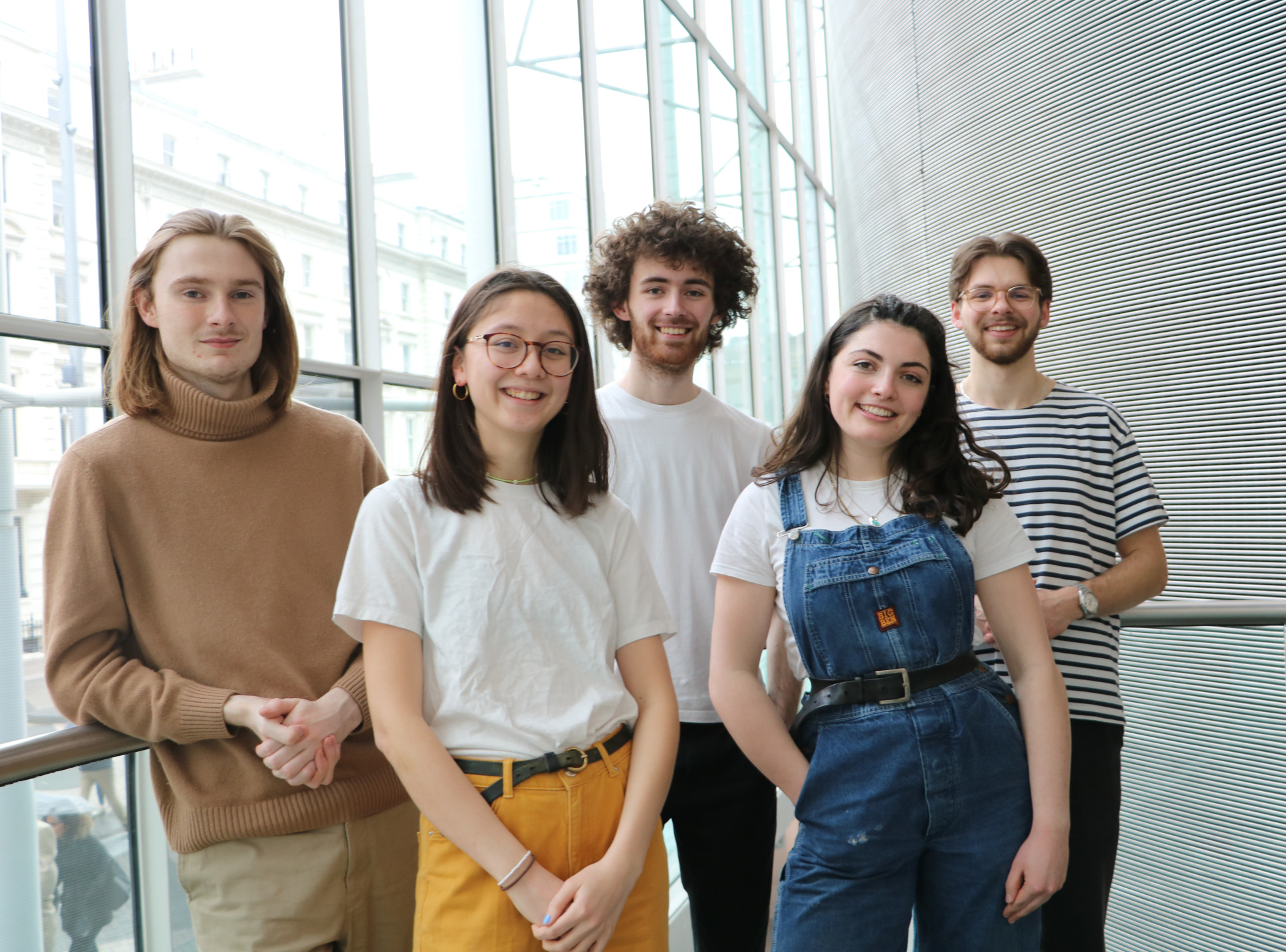 Five people standing in the College main entrance