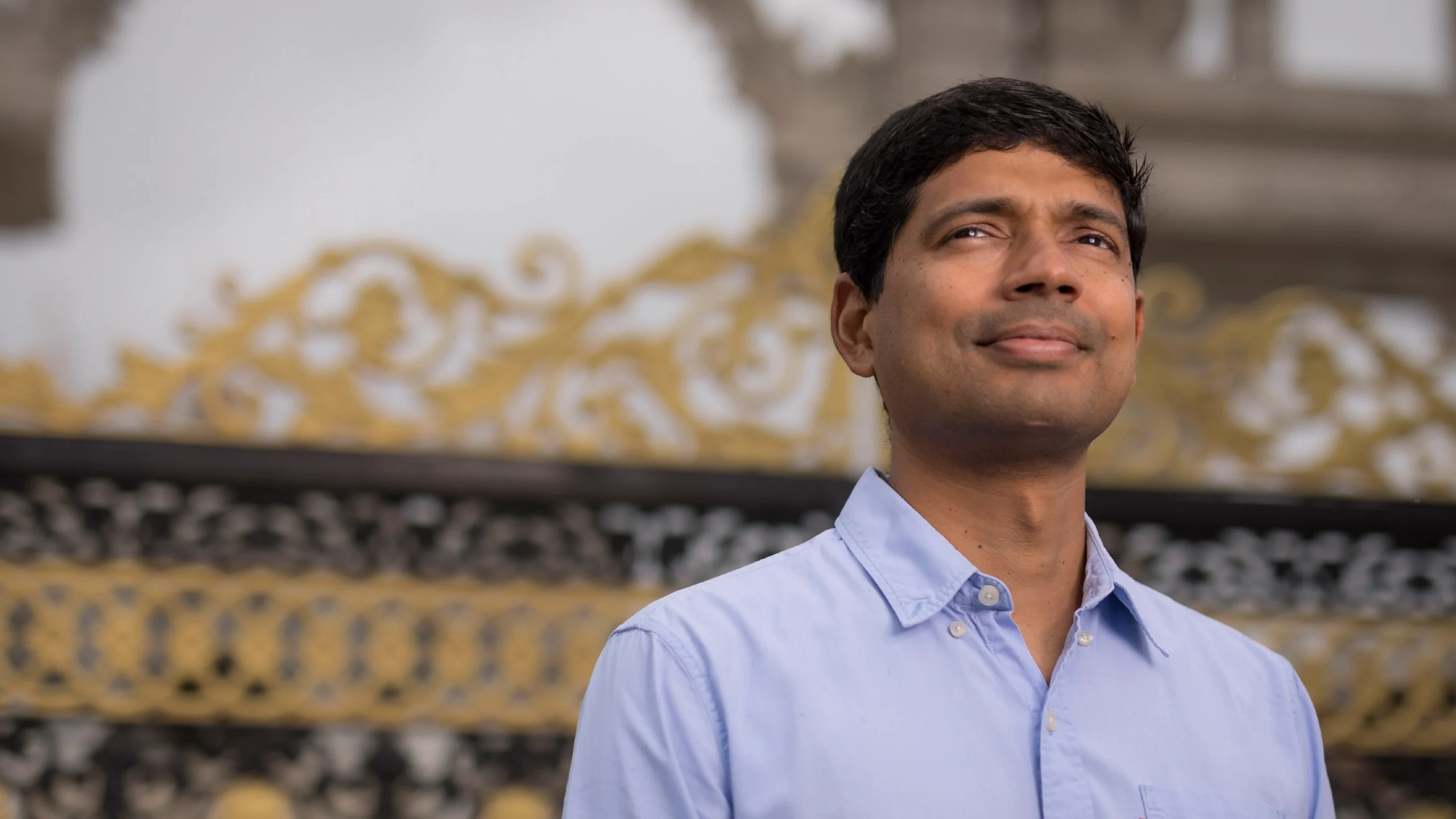 Dr Binoy Paulose Nadappuram stands at the gates of Buckingham Palace